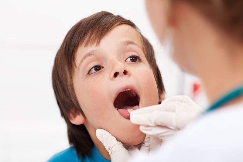 Say aaah - little boy having his throat examined by health professional - closeup