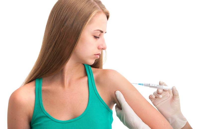 flu vaccination shot by syringe to a young woman