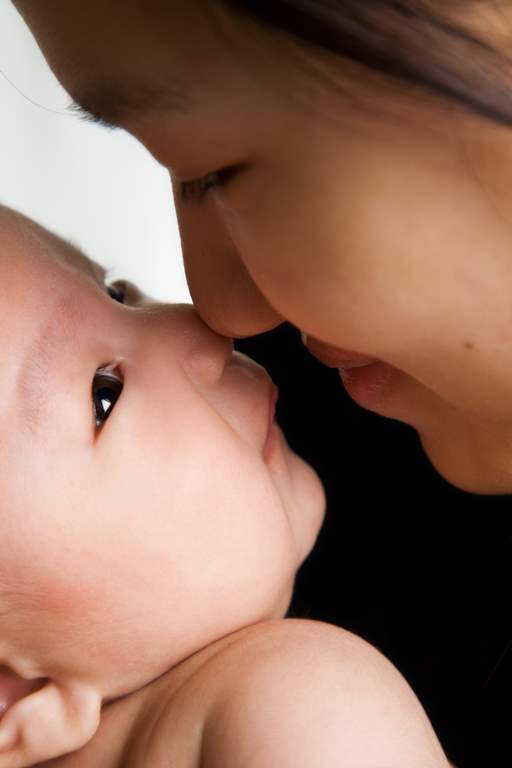 A shot of an asian mother kissing her baby boy
