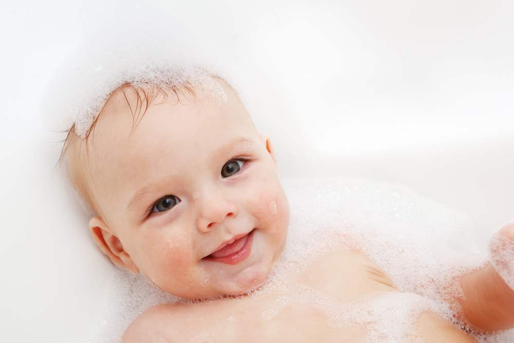 Adorable bath baby boy with soap suds on hair