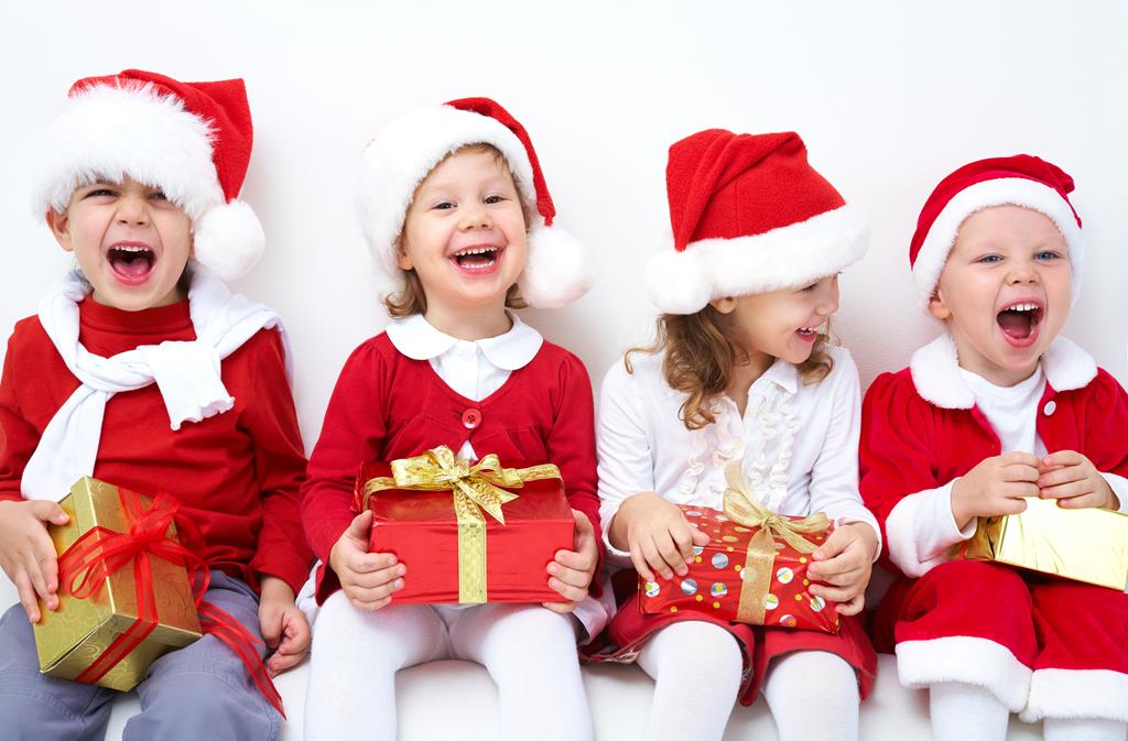 Group of four children in Christmas hat with presents