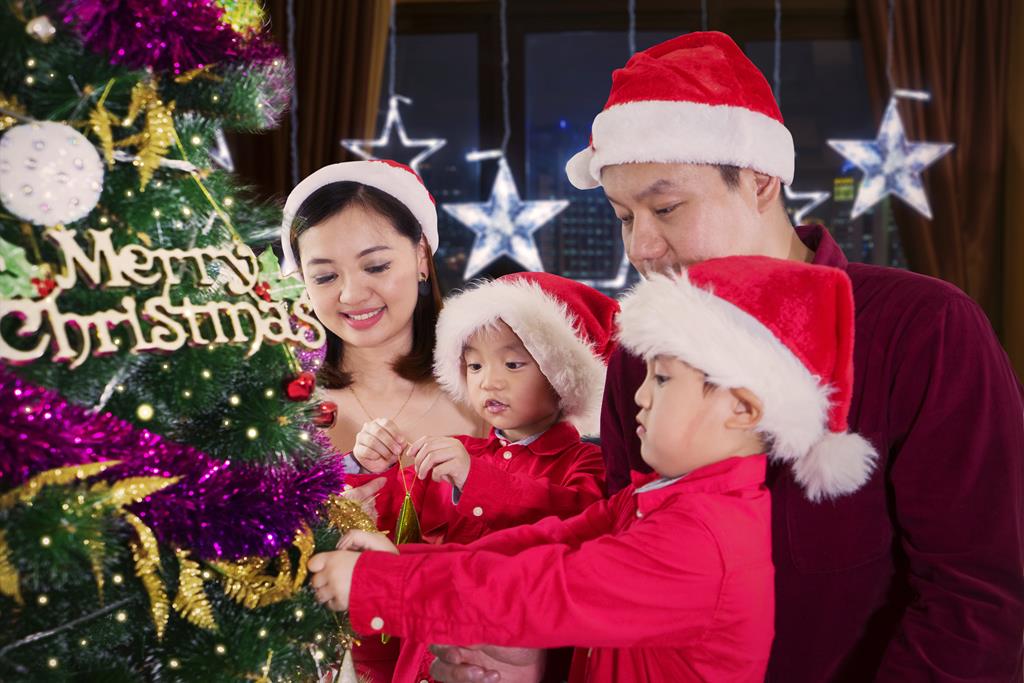 Asian family decorating Christmas tree