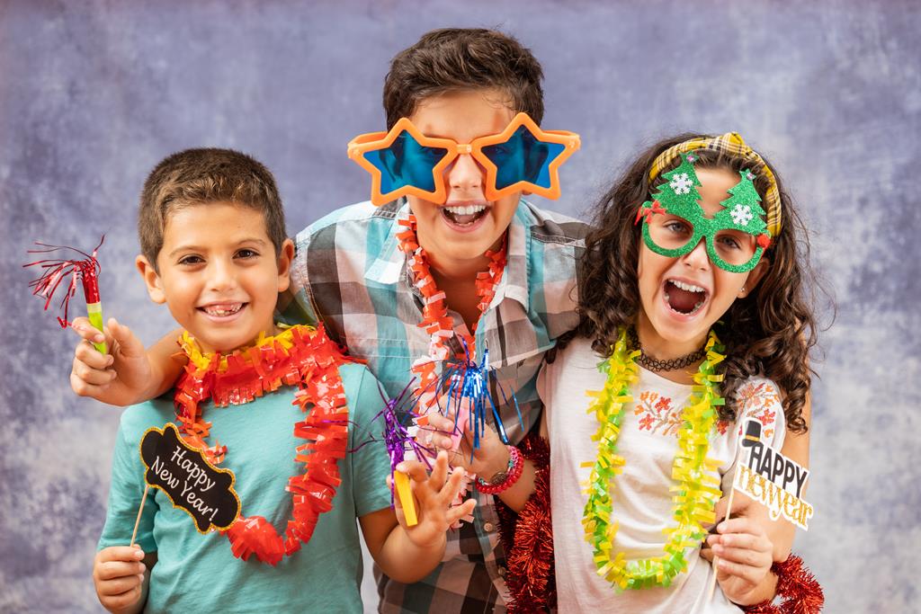 Three kids celebrating new years Eve.