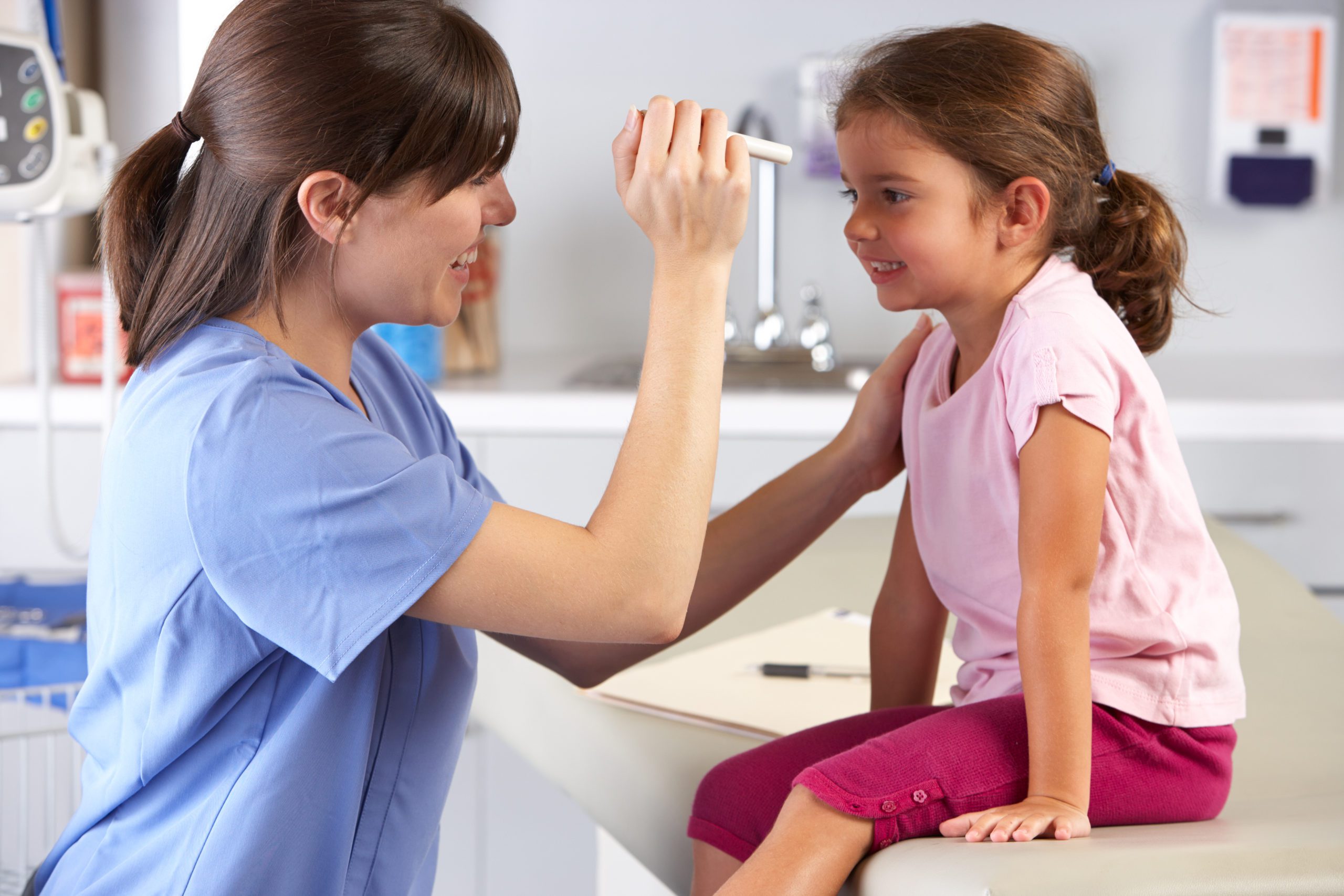 Pediatrician examining a young child in a doctor's office.
